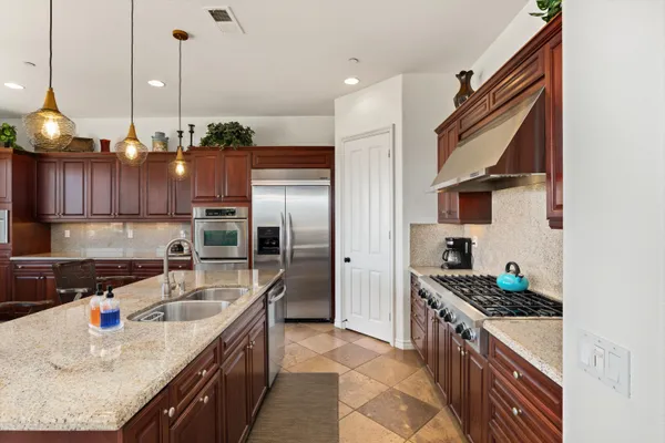 a kitchen with a dining table chairs and a kitchen view