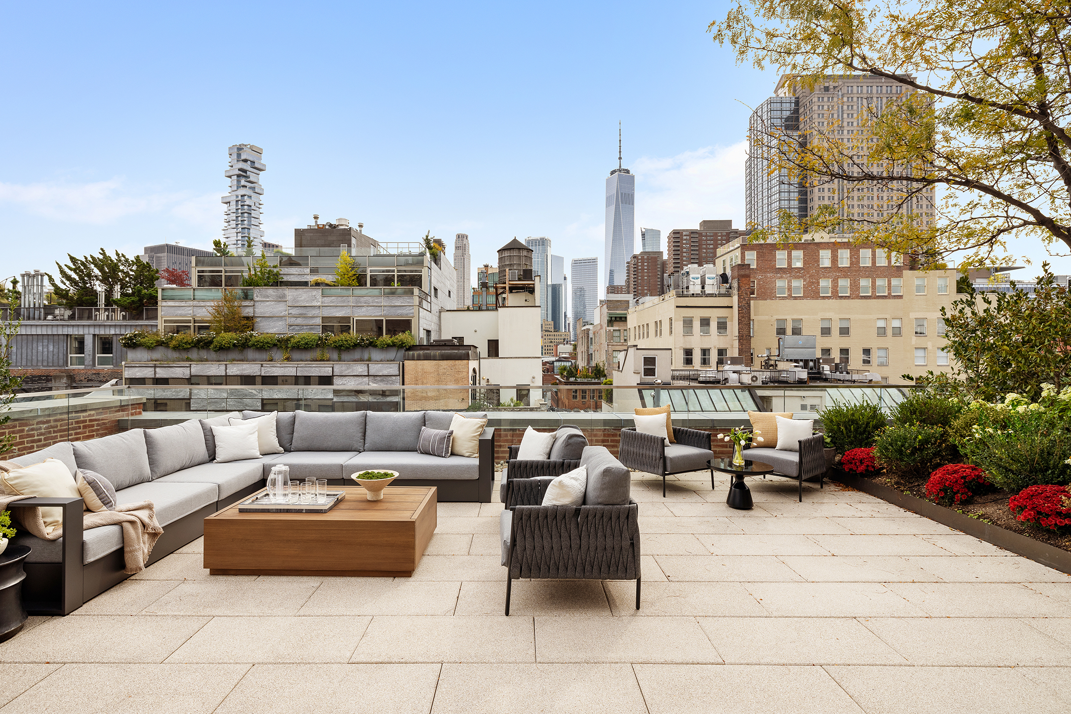 a roof deck with couches and potted plants