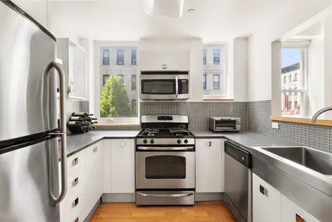 a kitchen with cabinets stainless steel appliances and a sink