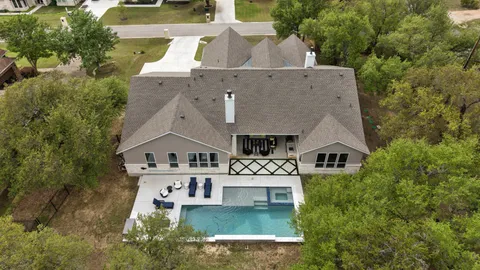 an aerial view of residential houses with outdoor space and trees