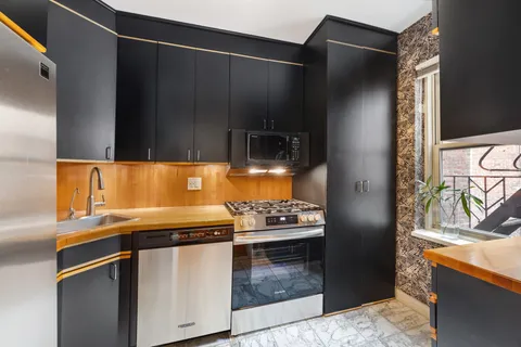 a kitchen with stainless steel appliances granite countertop a refrigerator and a stove