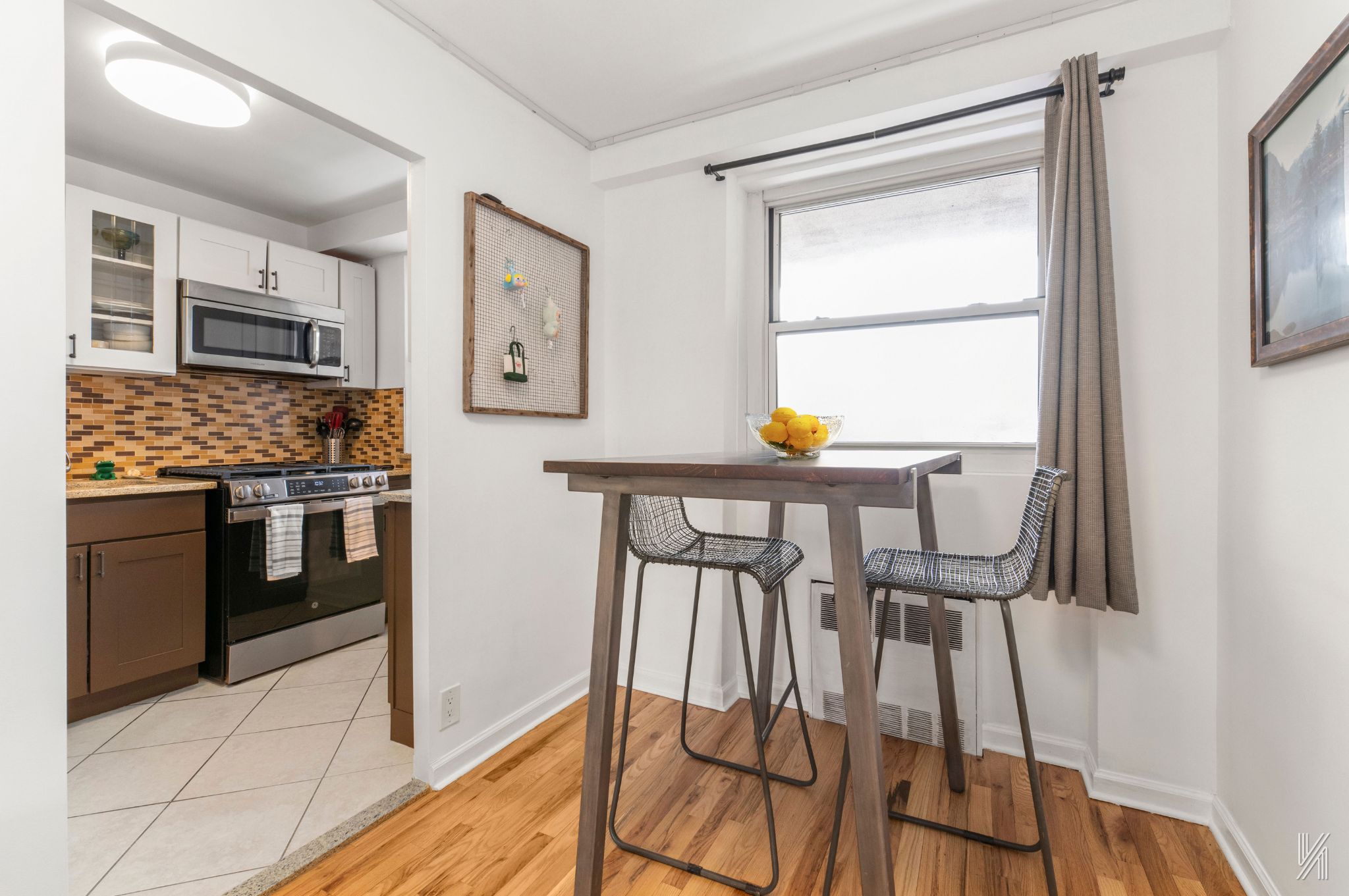 35-50 85th Street, Unit 7H Queens, NY 11372 - Photo 6 of 16 a kitchen with stainless steel appliances kitchen island granite countertop a stove a refrigerator with white cabinets and wooden floor