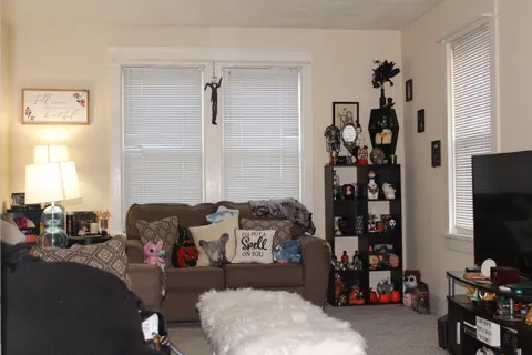 a bedroom with furniture a air conditioner vent and a window