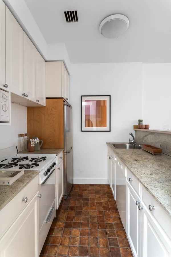 a kitchen with stainless steel appliances granite countertop a stove a sink and a refrigerator