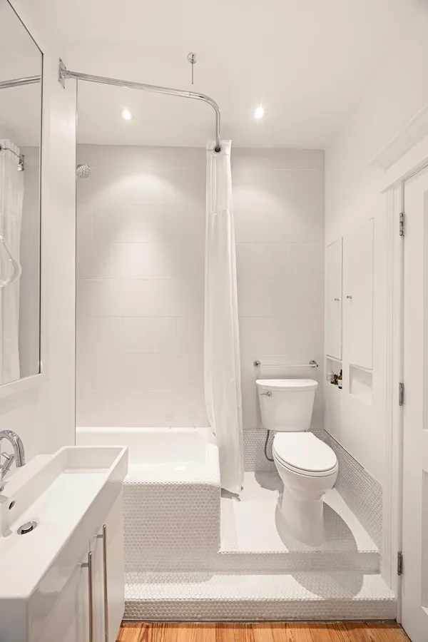 a bathroom with a bathtub shower sink vanity and toilet
