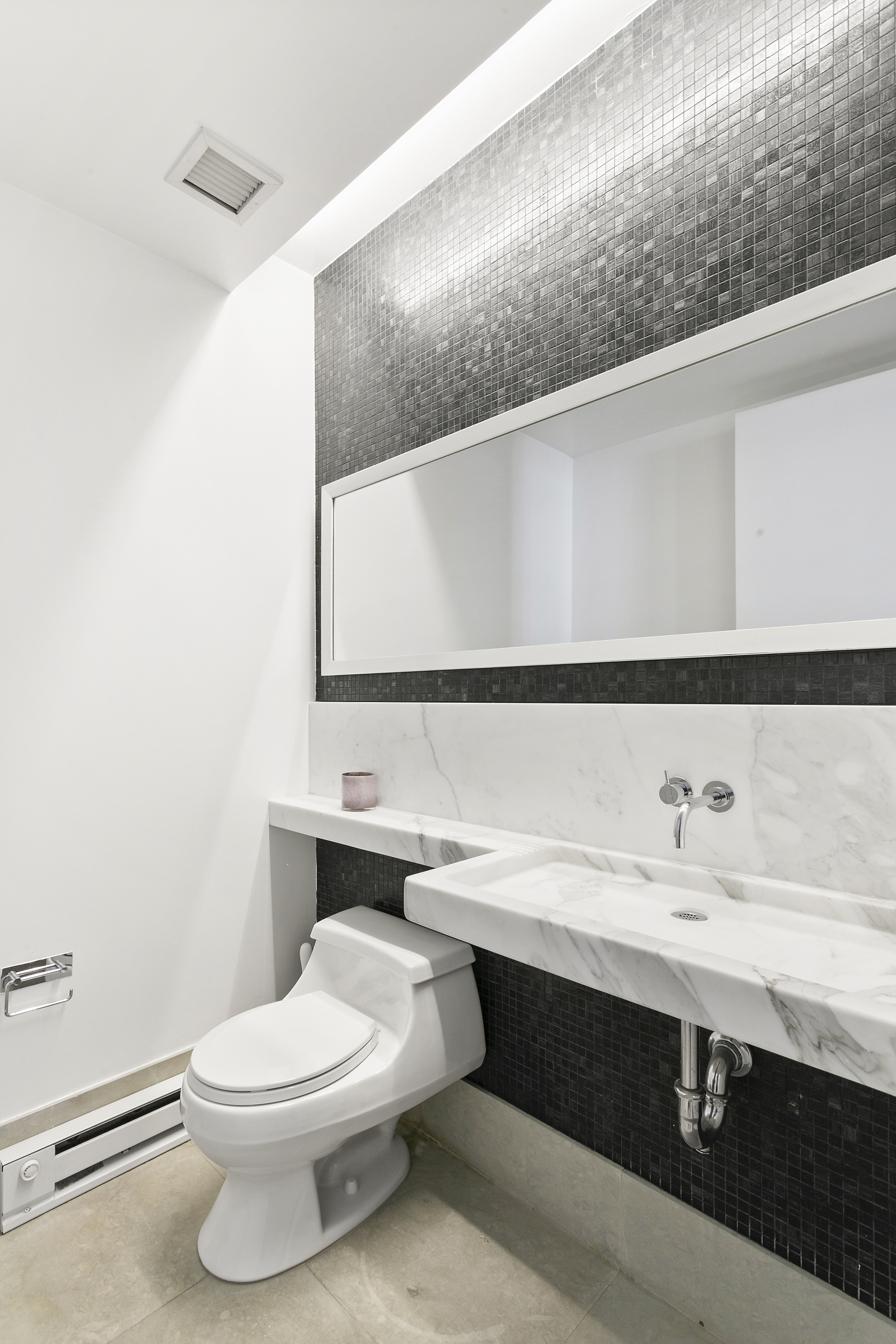 150 Nassau Street, Unit 19A Manhattan, NY 10038 - Photo 8 of 16 a bathroom with a sink a toilet and mirror