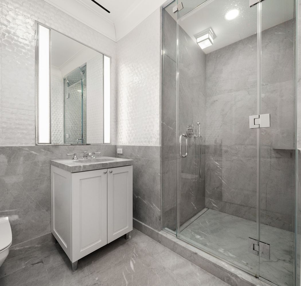 a bathroom with a granite countertop sink a mirror and shower