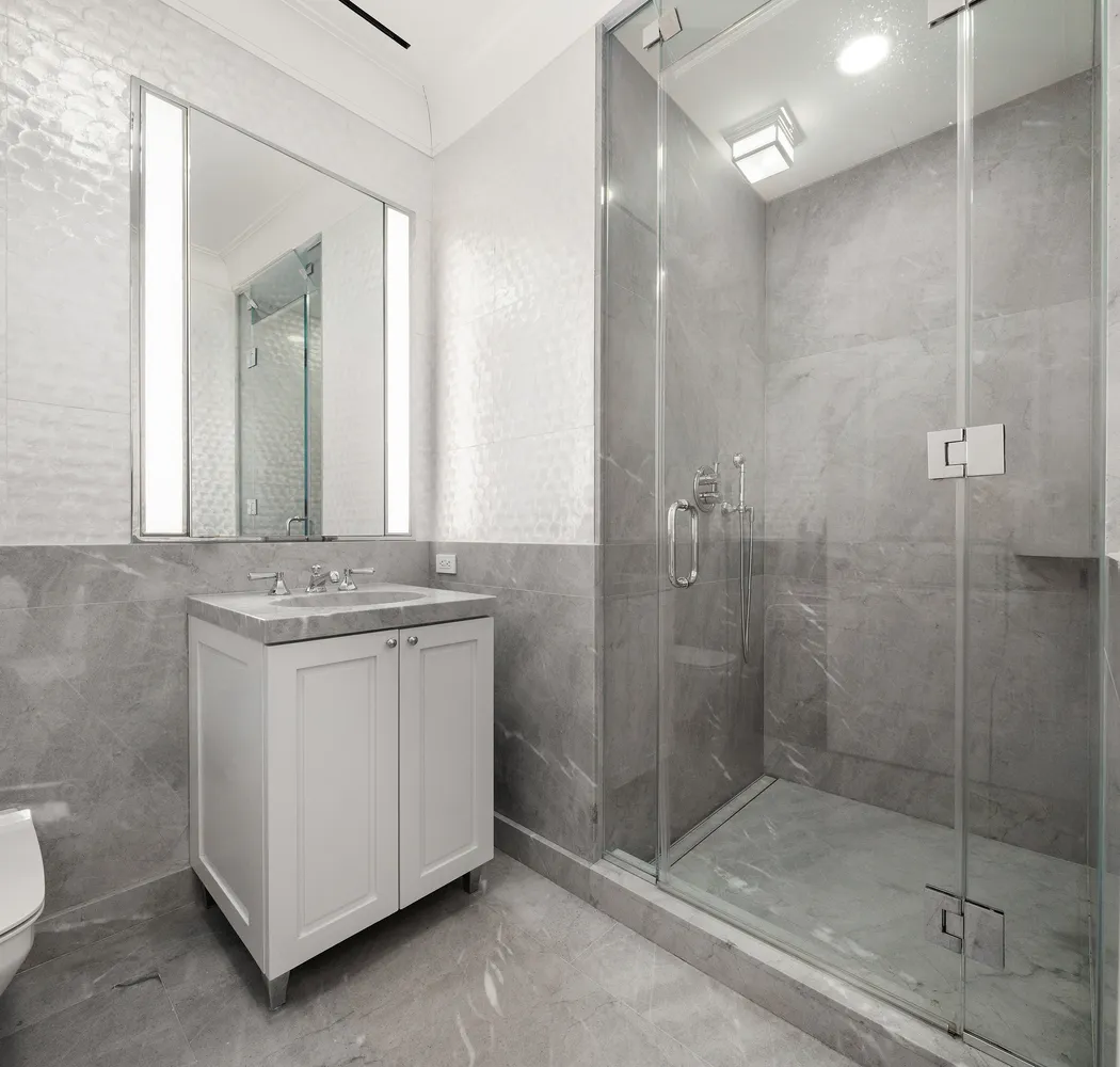 a bathroom with a granite countertop sink a mirror and shower