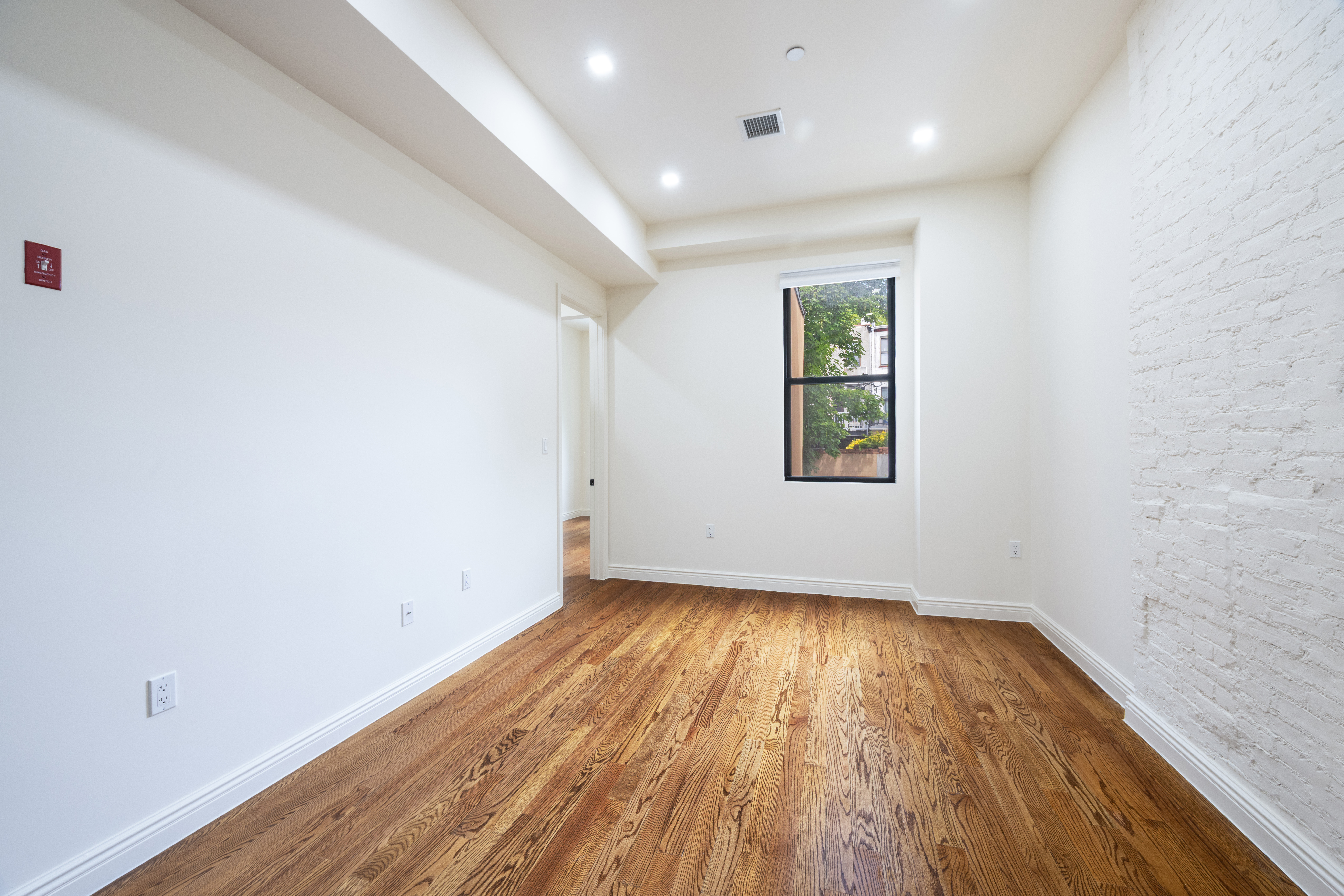 437 Putnam Avenue, Unit 2 Brooklyn, NY 11221 - Photo 8 of 9 an empty room with wooden floor and windows