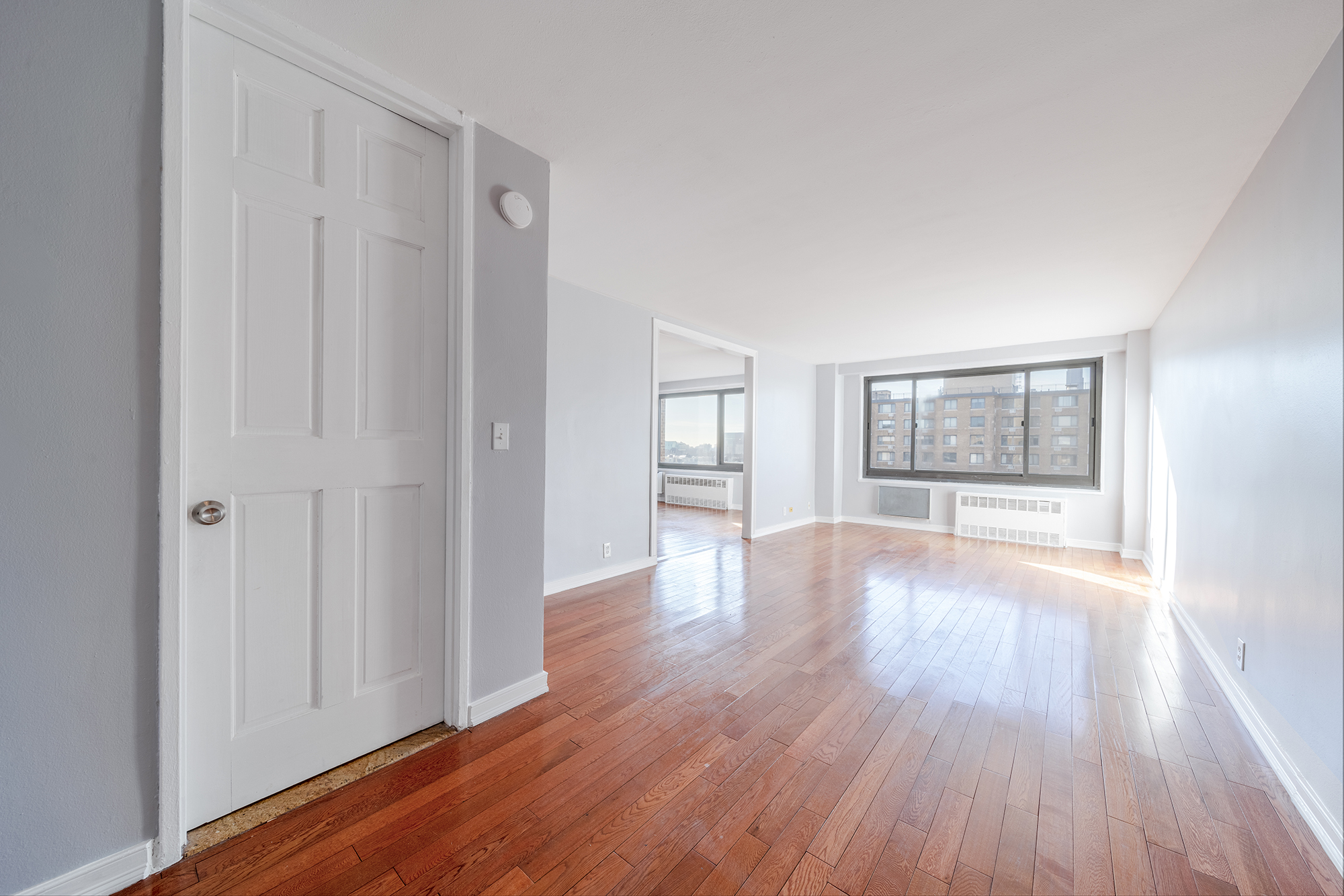 195 Willoughby Avenue, Unit 1517/1518 Brooklyn, NY 11205 - Photo 9 of 11 a view of an empty room with window and wooden floor