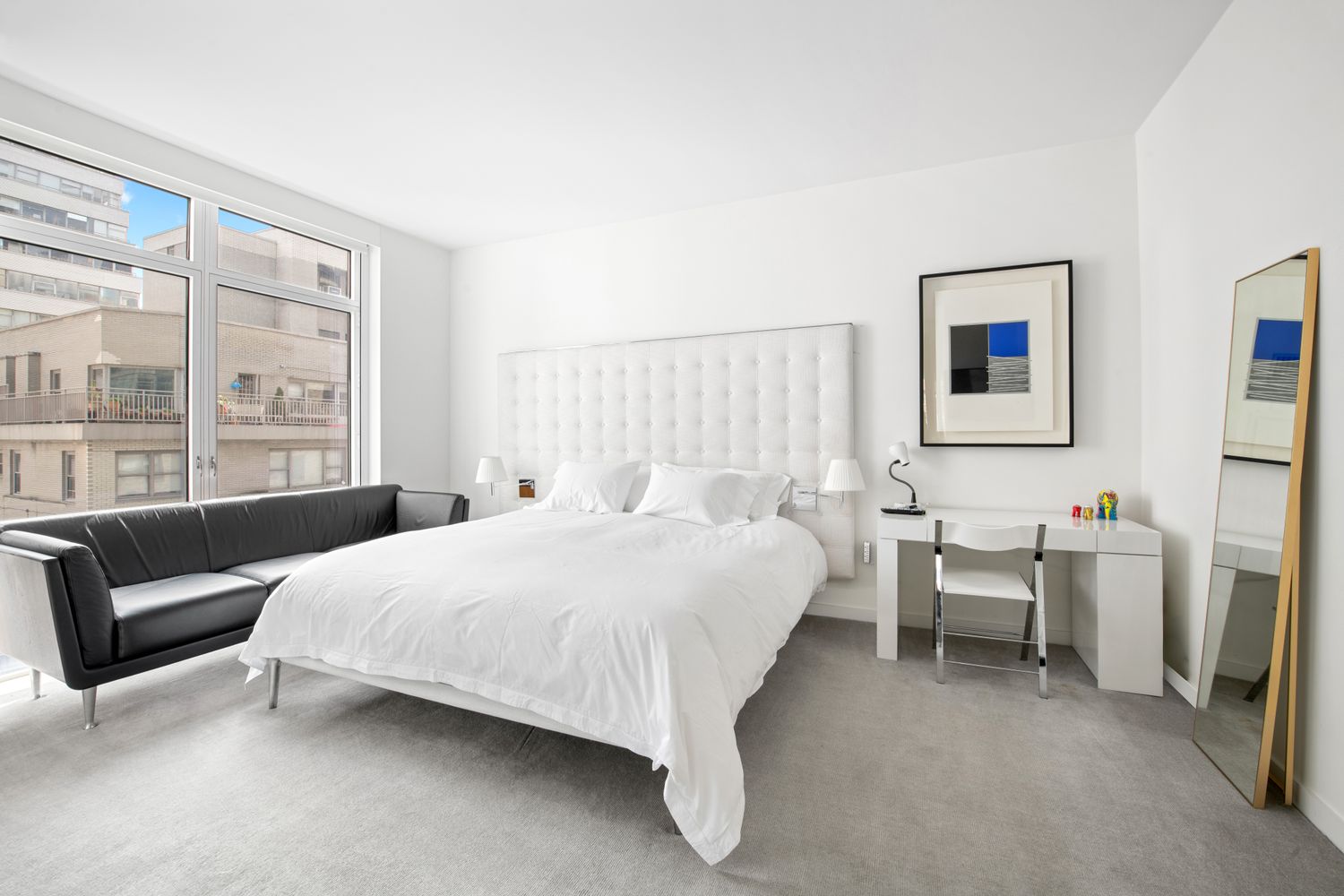 207 East 57th Street, Unit 12A Manhattan, NY 10022 - Photo 6 of 13 a bedroom with a bed couch and a window