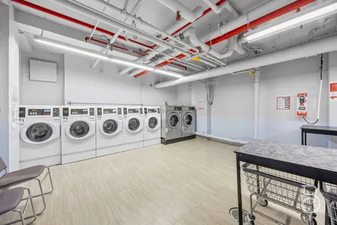 a utility room with stainless steel appliances wooden floor washer and dryer