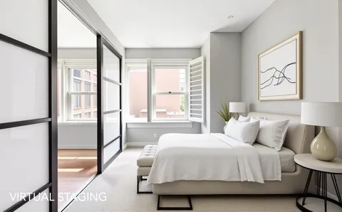 a bedroom with a bed and a large window