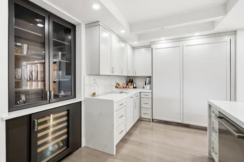 a kitchen with stainless steel appliances white cabinets and a refrigerator
