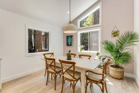 a dining room with furniture potted plants and wooden floor