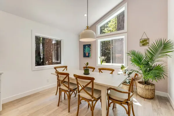 a dining room with furniture potted plants and wooden floor