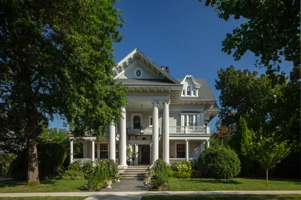 a view of a building with a yard and fountain in front of house