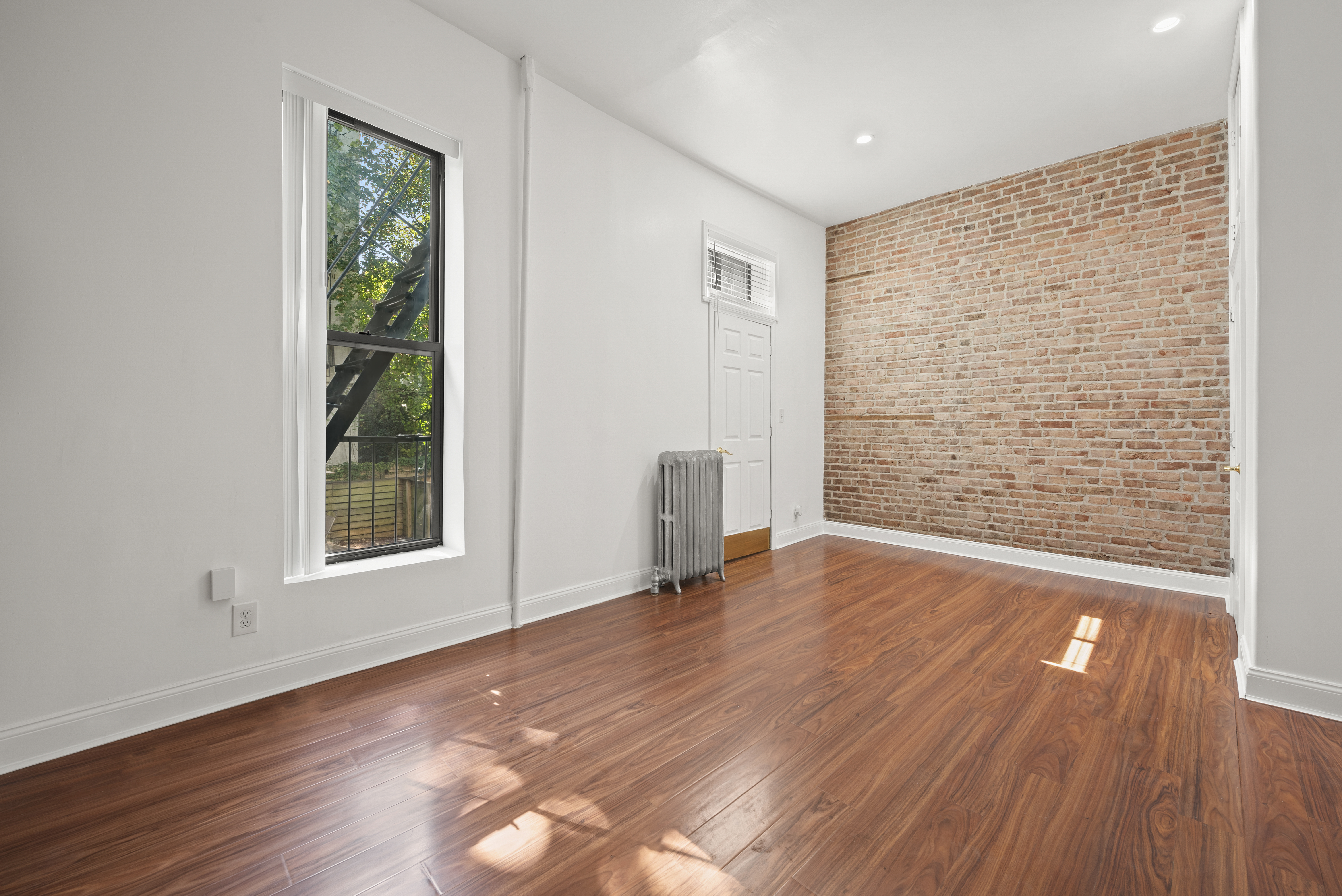654 Lafayette Avenue, Unit GARDENA Brooklyn, NY 11216 - Photo 5 of 14 a view of an empty room with wooden floor and a window