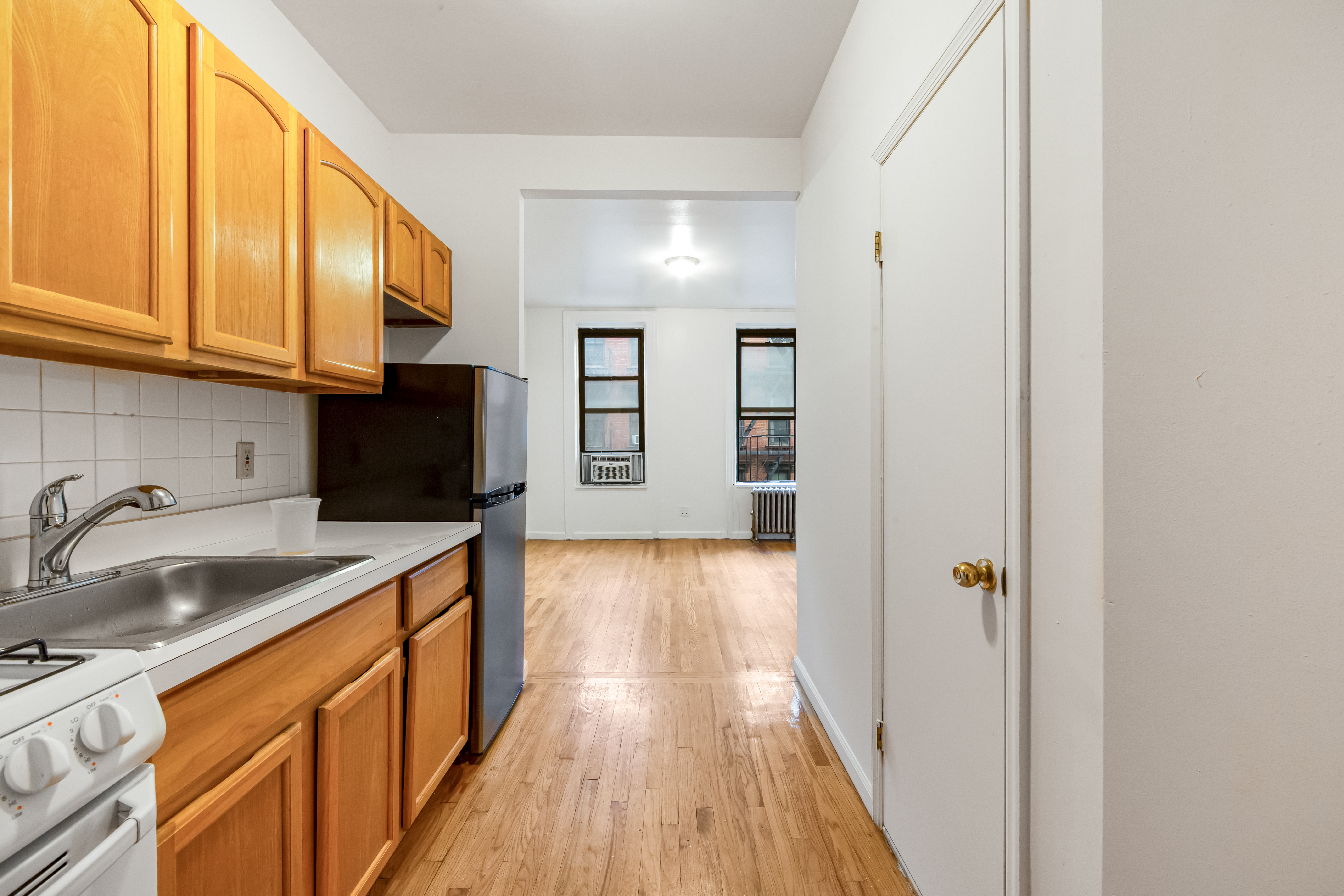 142 Sullivan Street, Unit 12 Manhattan, NY 10012 - Photo 5 of 12 a view of a kitchen with a sink and wooden floor