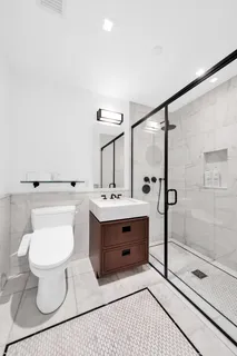 a bathroom with a sink toilet a mirror and shower