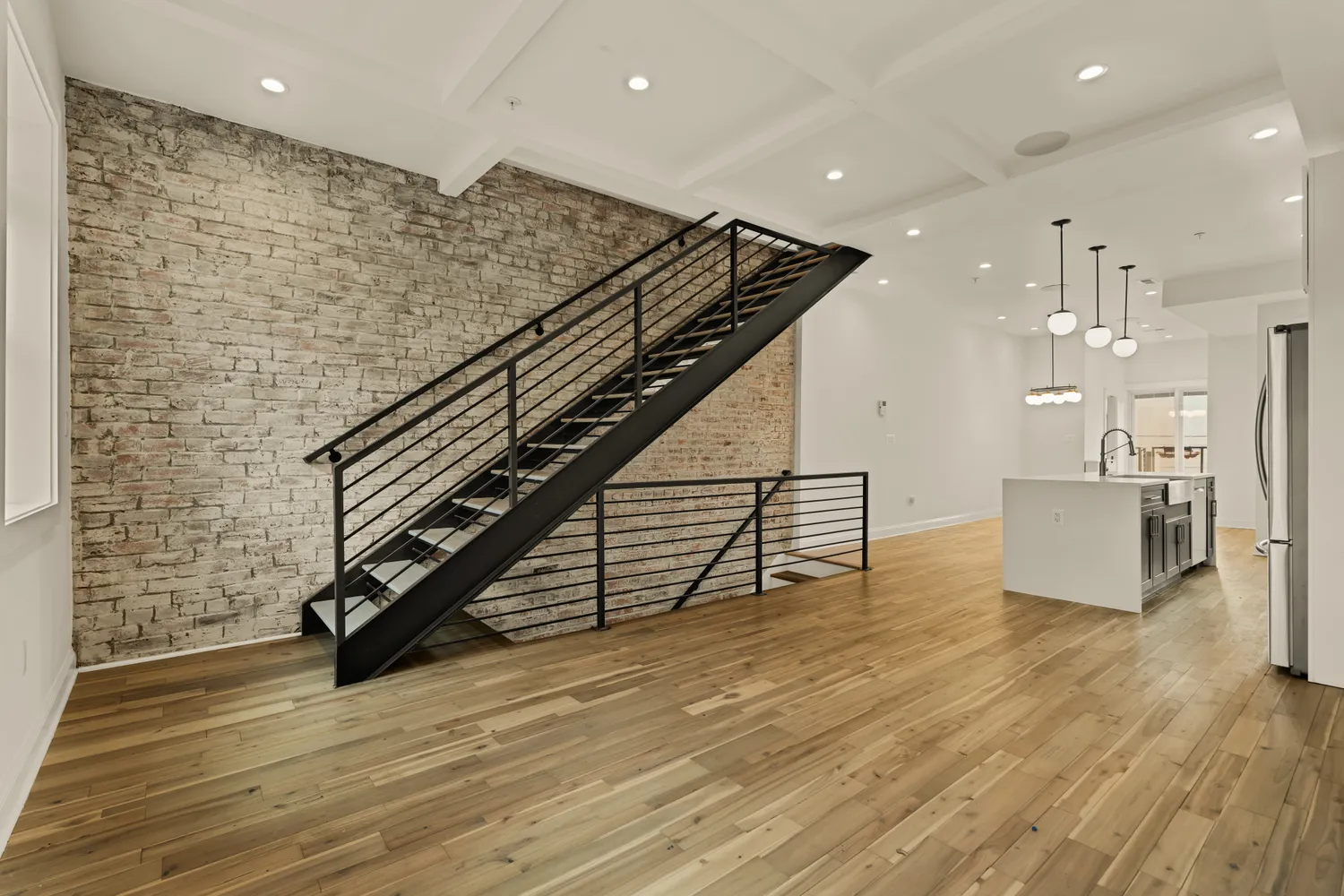 a view of a hall with wooden floor and stairs