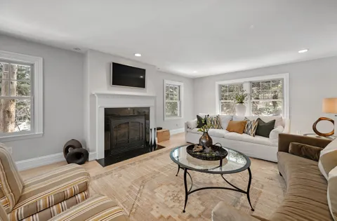a living room with furniture a flat screen tv and a fireplace