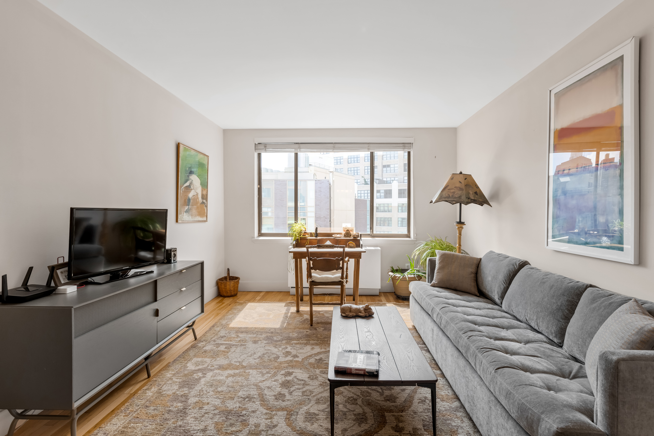 63 Downing Street, Unit 8C Manhattan, NY 10014 - Photo 10 of 15 a living room with furniture and a flat screen tv