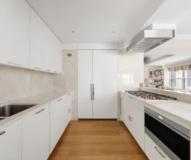 a kitchen with white cabinets and white appliances