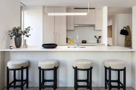 a kitchen with stainless steel appliances a table and chairs in it