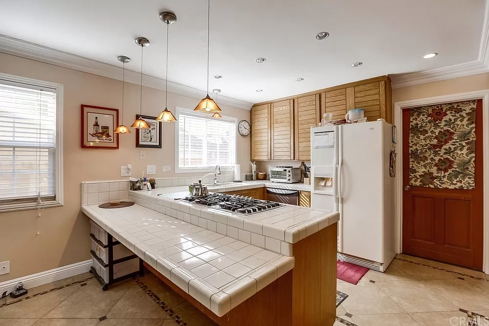 15604 Deblynn Avenue Gardena, CA 90248 - Photo 22 of 22 a kitchen with stainless steel appliances granite countertop a refrigerator a sink dishwasher a stove a dining table and chairs with wooden floor