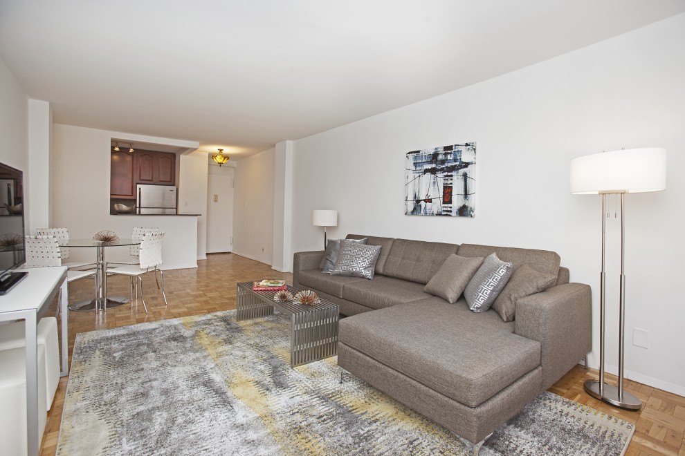 320 East 54th Street, Unit 8B Manhattan, NY 10022 - Photo 2 of 6 a living room with furniture and a flat screen tv