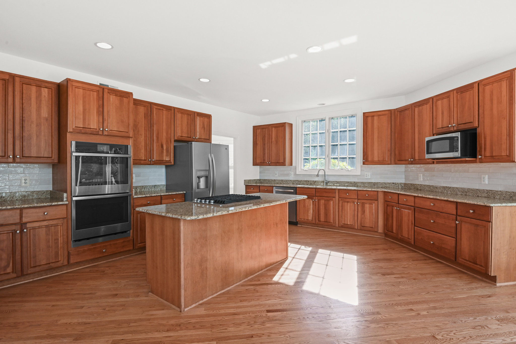 2628 Five Oaks Road Vienna, VA 22181 - Photo 15 of 40 a kitchen with stainless steel appliances granite countertop a stove a sink dishwasher a refrigerator and a microwave oven with wooden cabinets