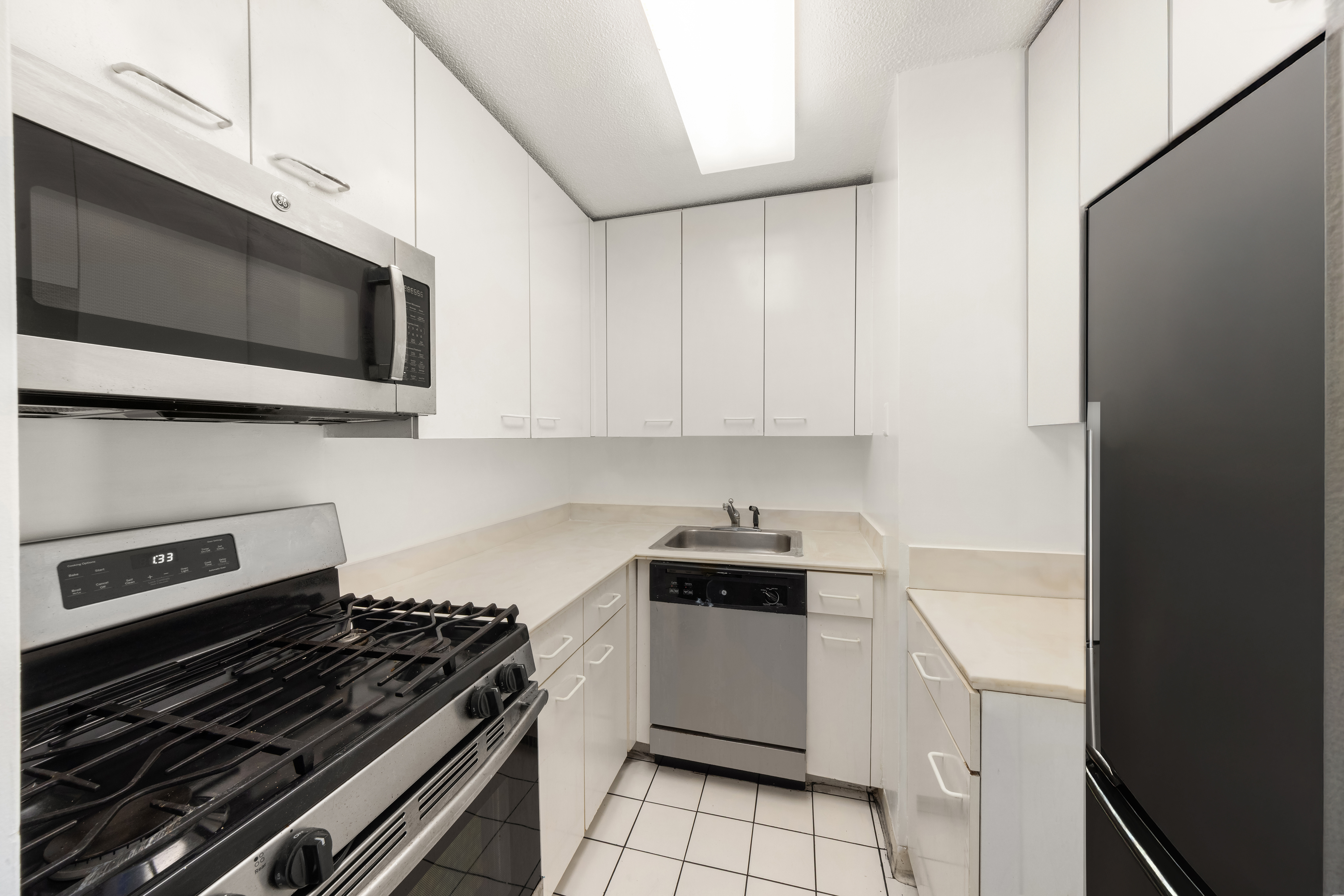 330 East 38th Street, Unit 22H Manhattan, NY 10016 - Photo 9 of 11 a kitchen with a stove and a microwave