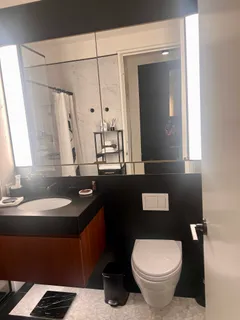 a bathroom with a granite countertop toilet sink and mirror