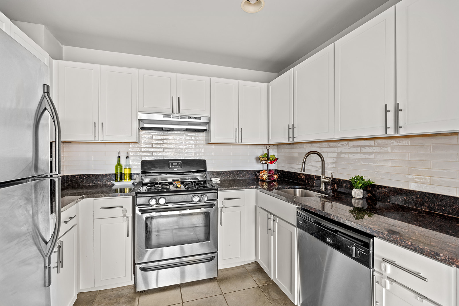 4102 Queens Boulevard, Unit 3D Queens, NY 11104 - Photo 2 of 7 a kitchen with granite countertop a stove sink and cabinets