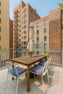 a roof deck with a table and chairs