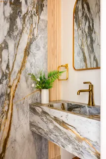 a spacious bedroom with a bed a couch and potted plant with the wooden floor