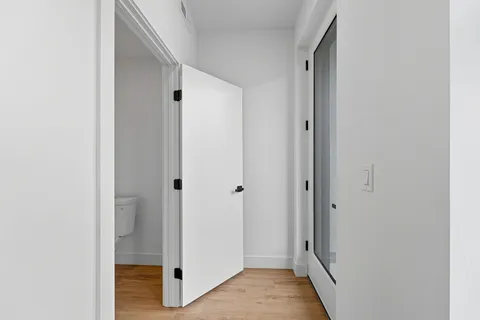 a view of a hallway with wooden floor