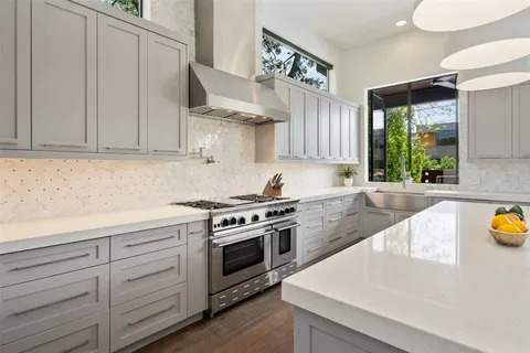 a kitchen with stainless steel appliances granite countertop a stove and a white cabinets