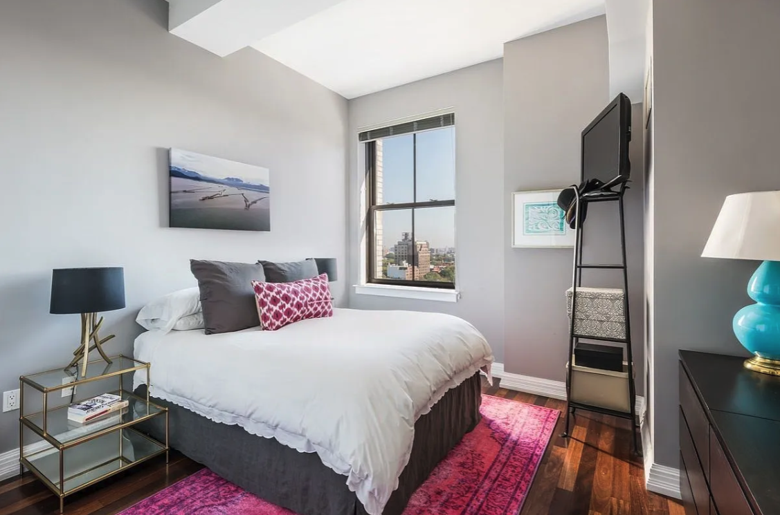 1 Hanson Place, Unit 15C Brooklyn, NY 11243 - Photo 3 of 8 a bedroom with a bed and wooden floor