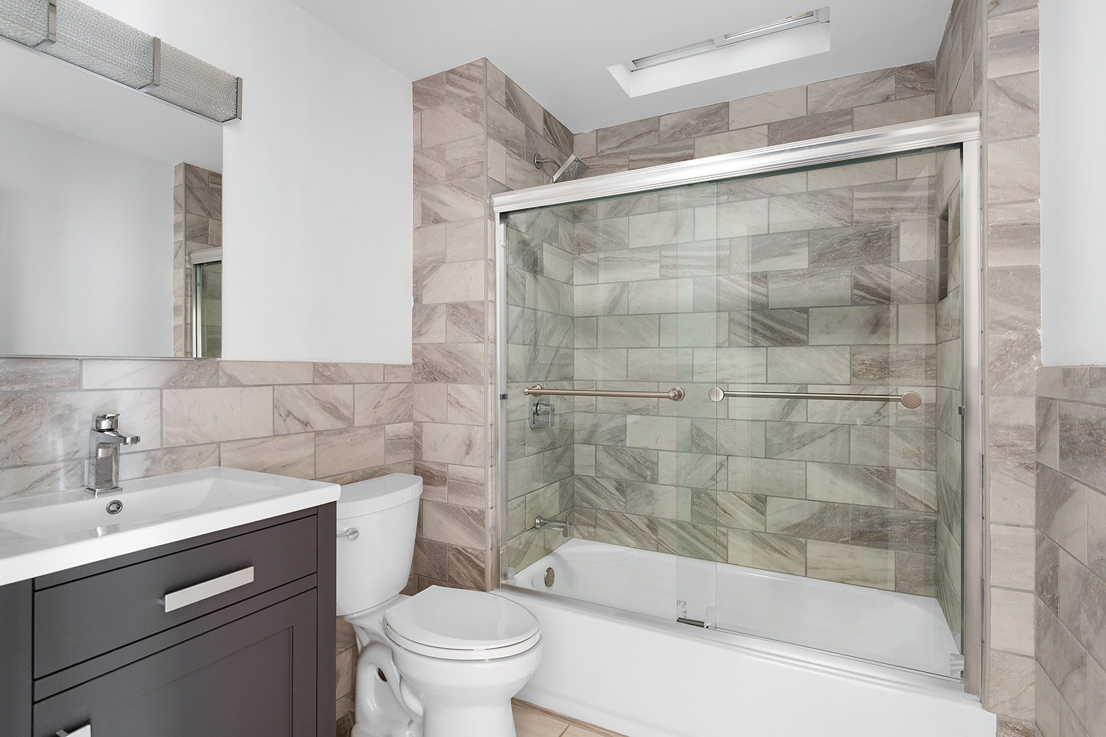 165 Fenimore Street Brooklyn, NY 11225 - Photo 6 of 13 a bathroom with a bathtub shower sink mirror and toilet