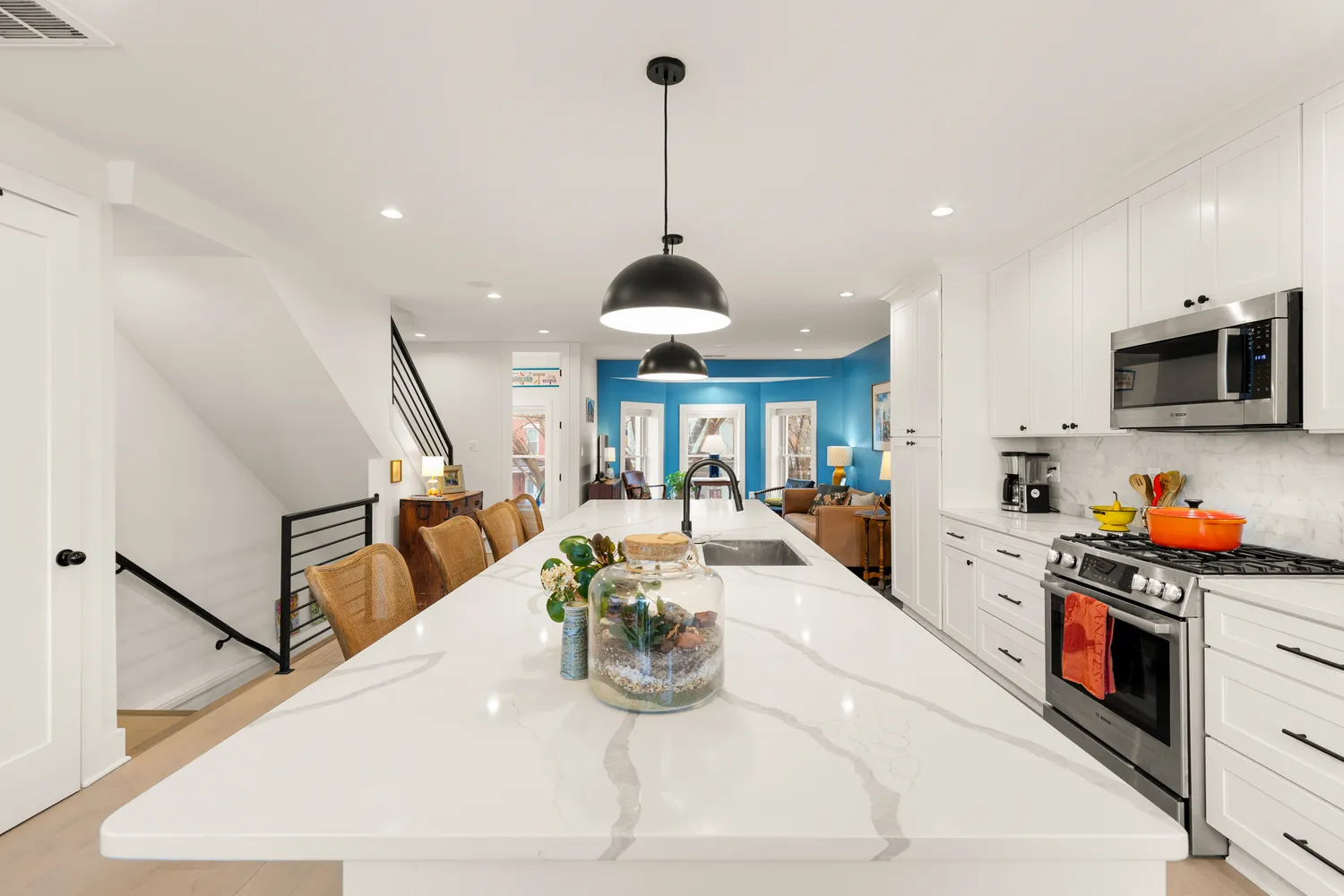 a kitchen with stainless steel appliances granite countertop a sink and a wooden floor
