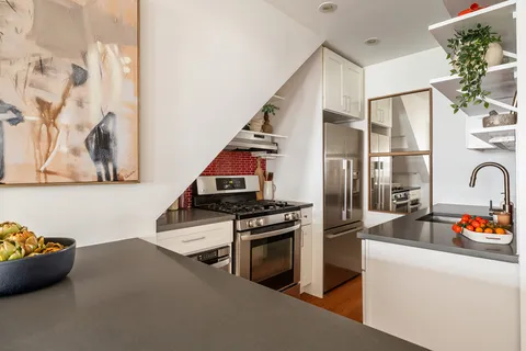 a kitchen with stainless steel appliances granite countertop a refrigerator and a stove top oven