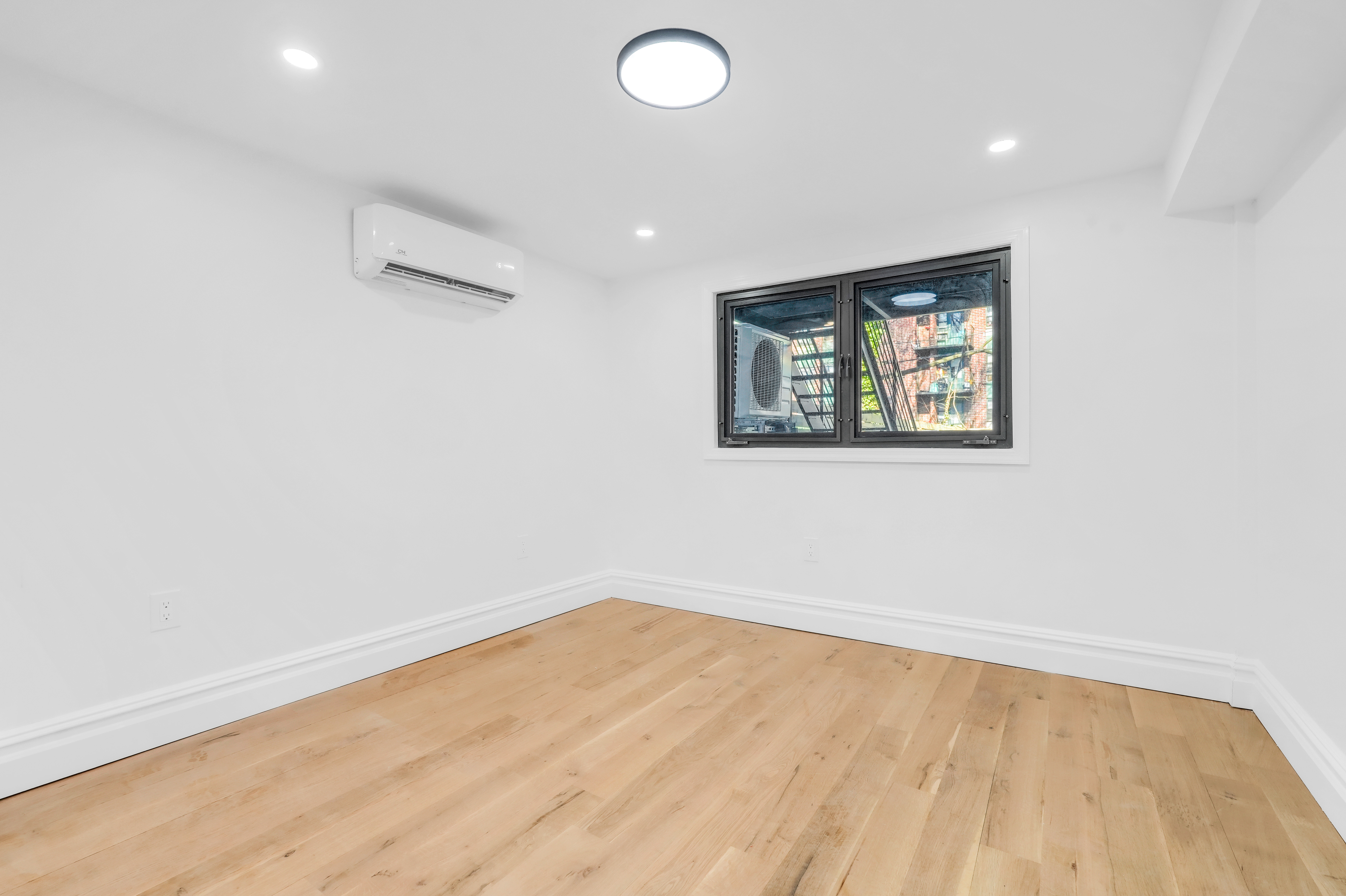 473 Monroe Street Brooklyn, NY 11221 - Photo 33 of 40 a view of empty room with wooden floor and fan