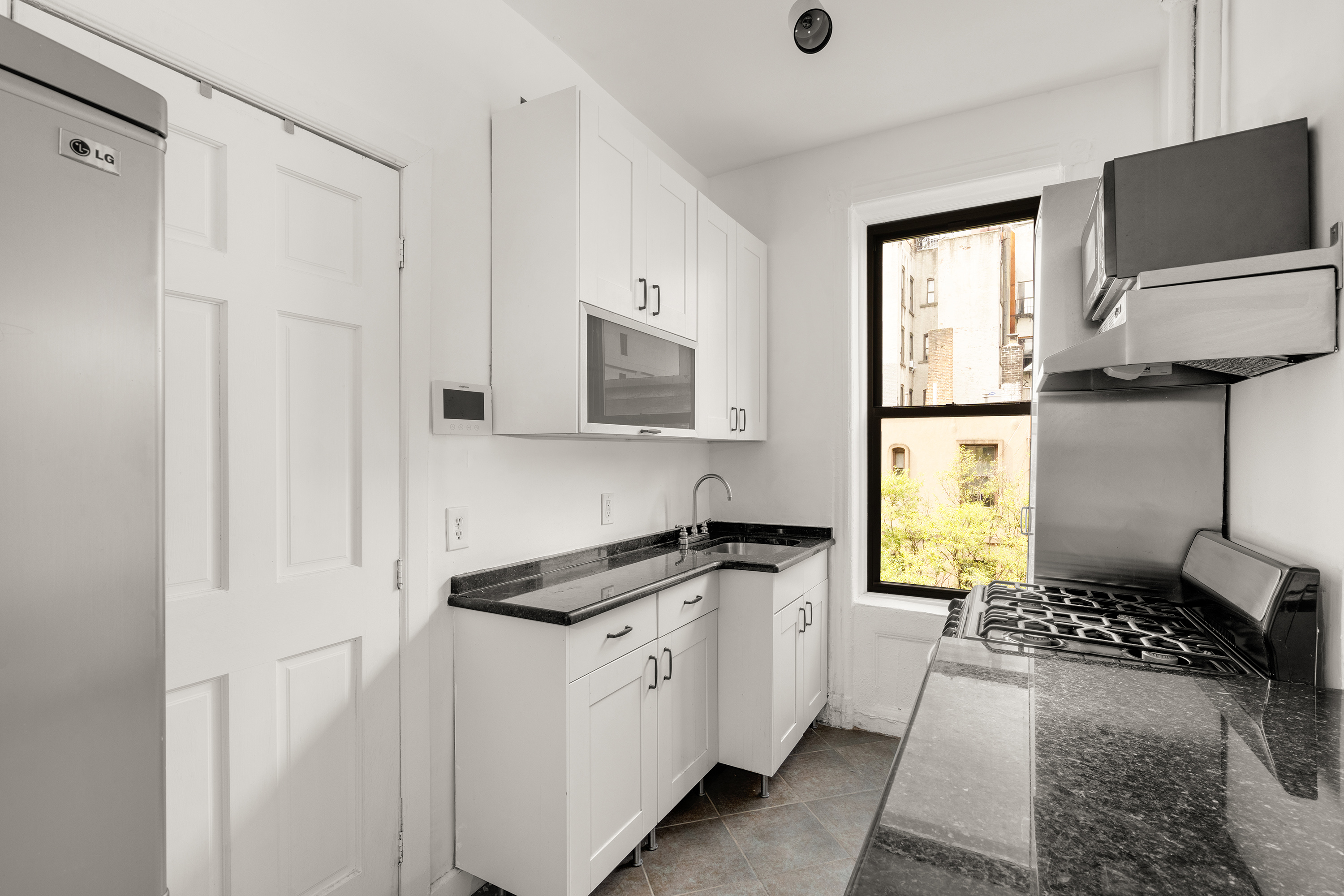 327 East 3rd Street, Unit 2E Manhattan, NY 10009 - Photo 2 of 5 a kitchen with stainless steel appliances a refrigerator sink and stove