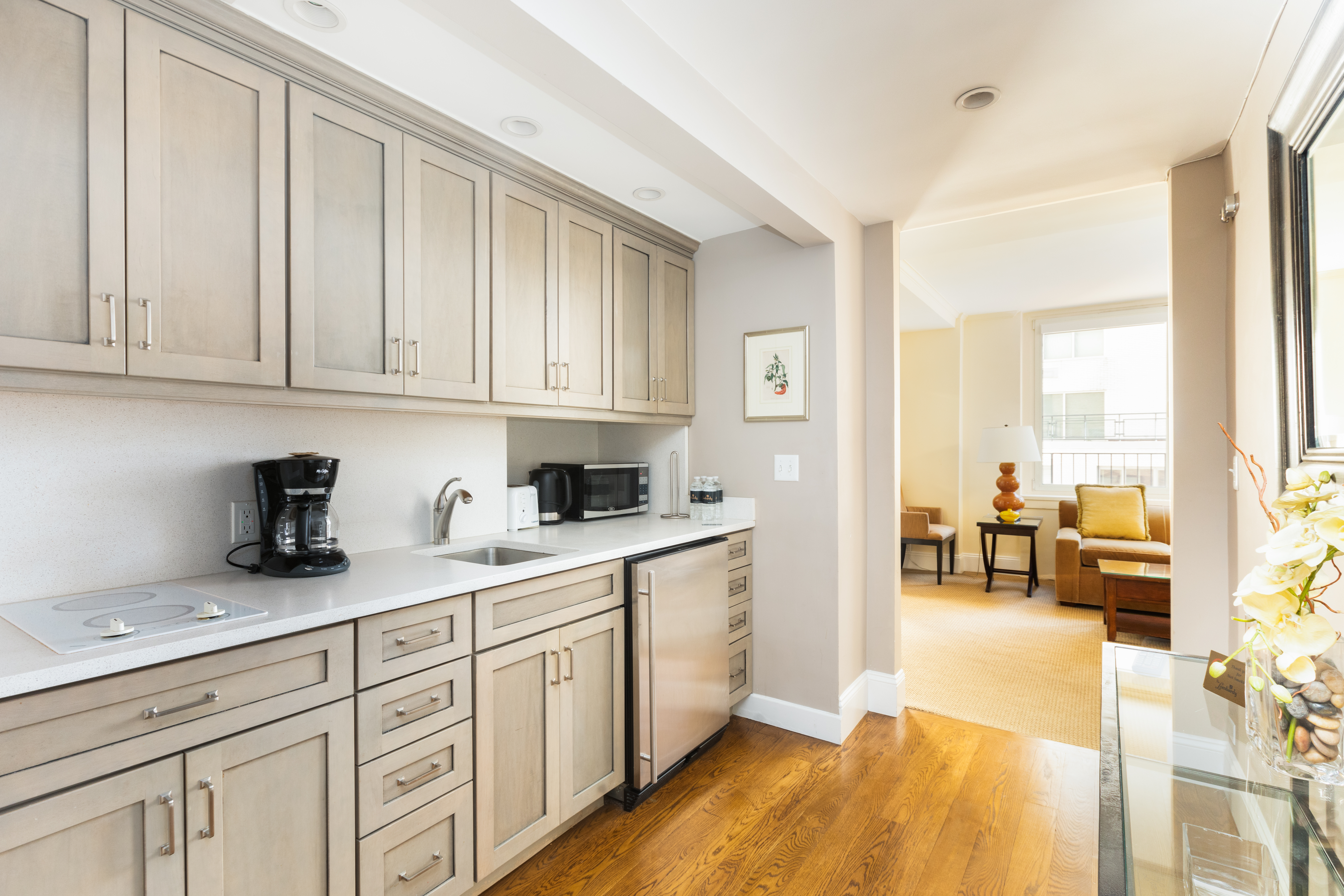 111 East 56th Street, Unit 1705 Manhattan, NY 10022 - Photo 6 of 12 a kitchen with granite countertop cabinets and living room view