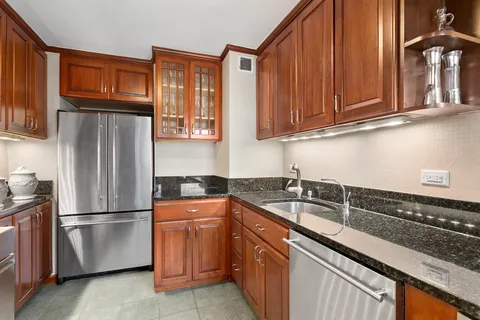 a kitchen with stainless steel appliances granite countertop a refrigerator and a sink