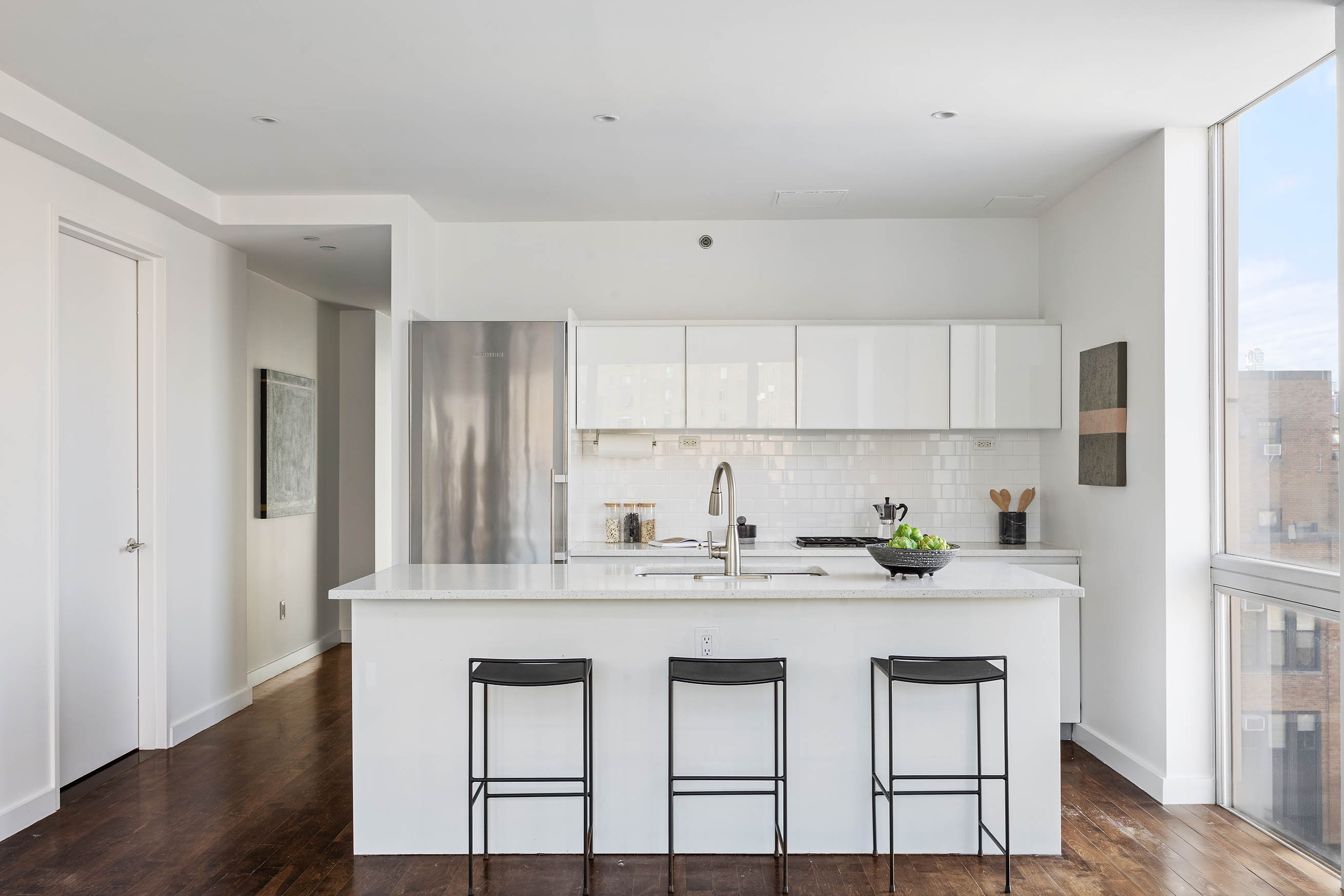 425 East 13th Street, Unit PHFG Manhattan, NY 10009 - Photo 6 of 31 a kitchen with stainless steel appliances granite countertop a white cabinets and wooden floor
