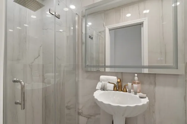 a bathroom with a sink a toilet and shower
