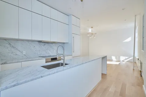 a kitchen with granite countertop a sink a stove and cabinets